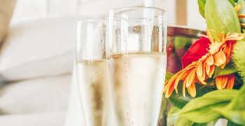 Two glasses of champagne in the upscale hotel room. Dating, romance, honeymoon, valentine, getaway concepts Two glasses of champagne in the upscale hotel room. Dating, romance, honeymoon, valentine, getaway concepts