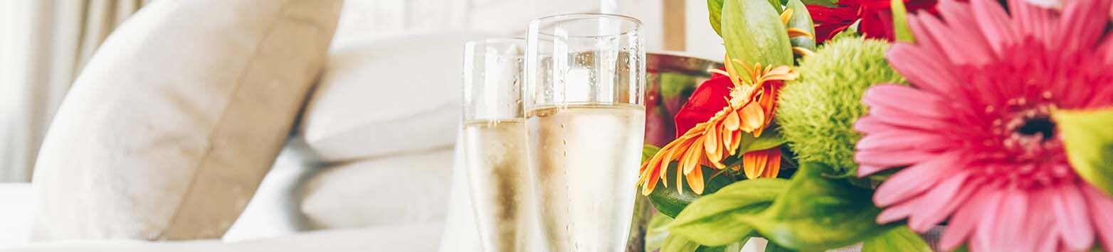 Two glasses of champagne in the upscale hotel room. Dating, romance, honeymoon, valentine, getaway concepts